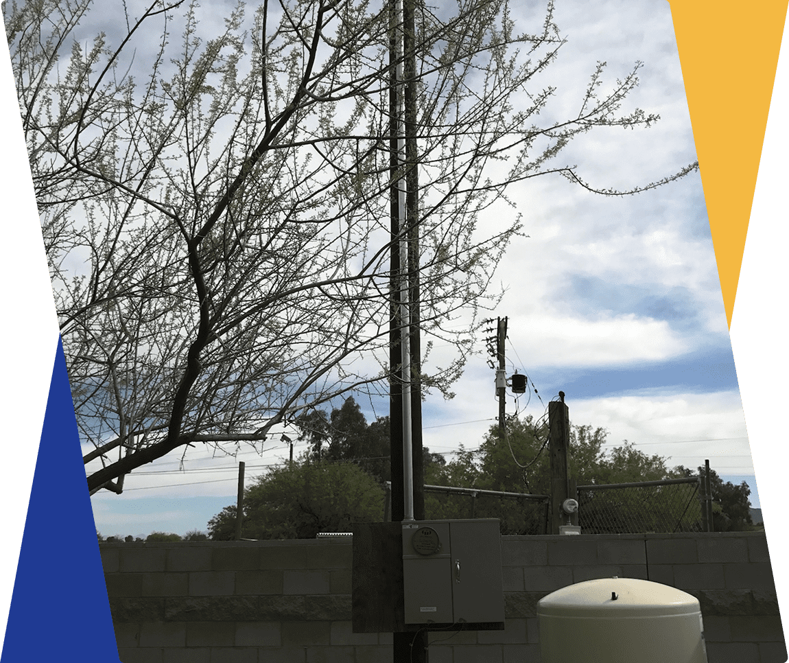 Tree and equipment near a concrete wall.