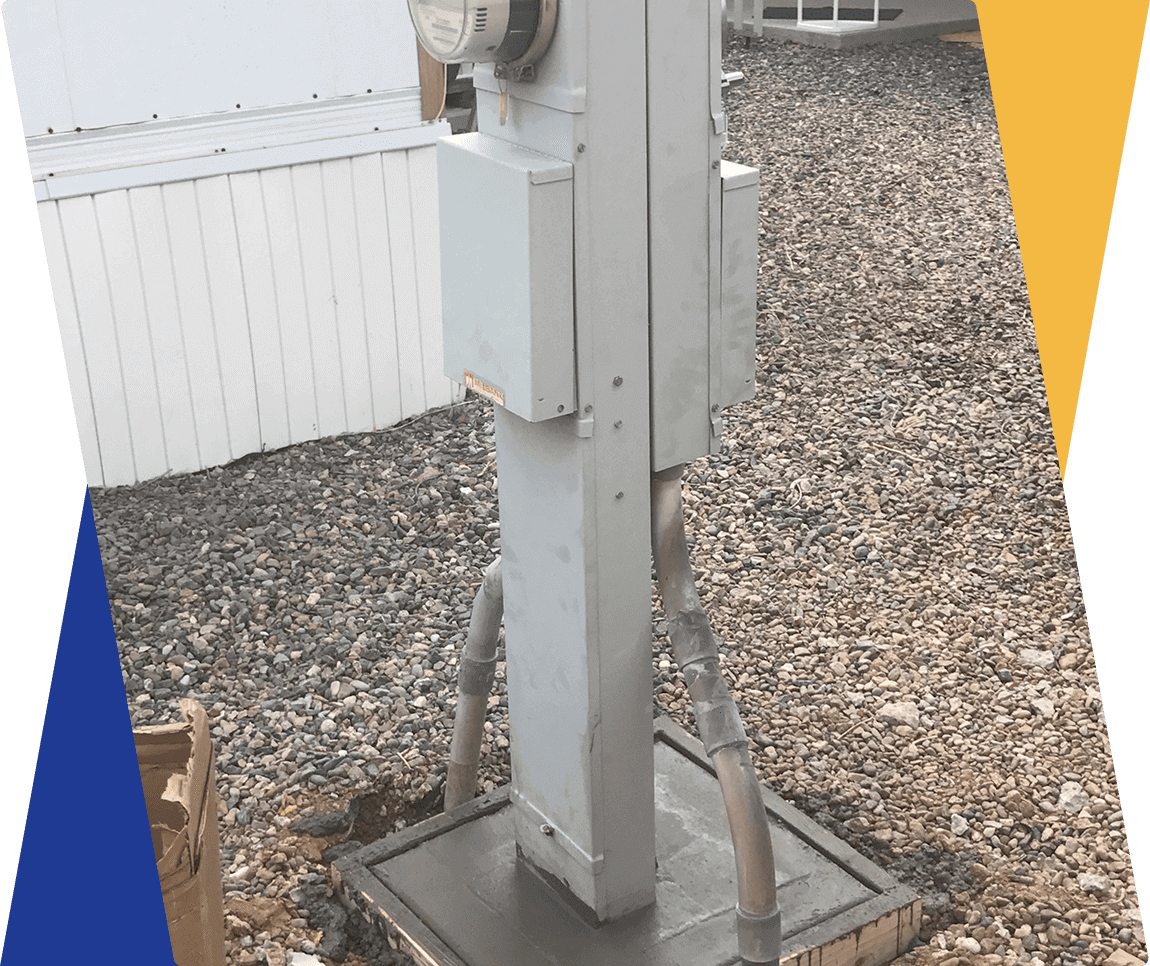 Electric meter box on gravel ground.