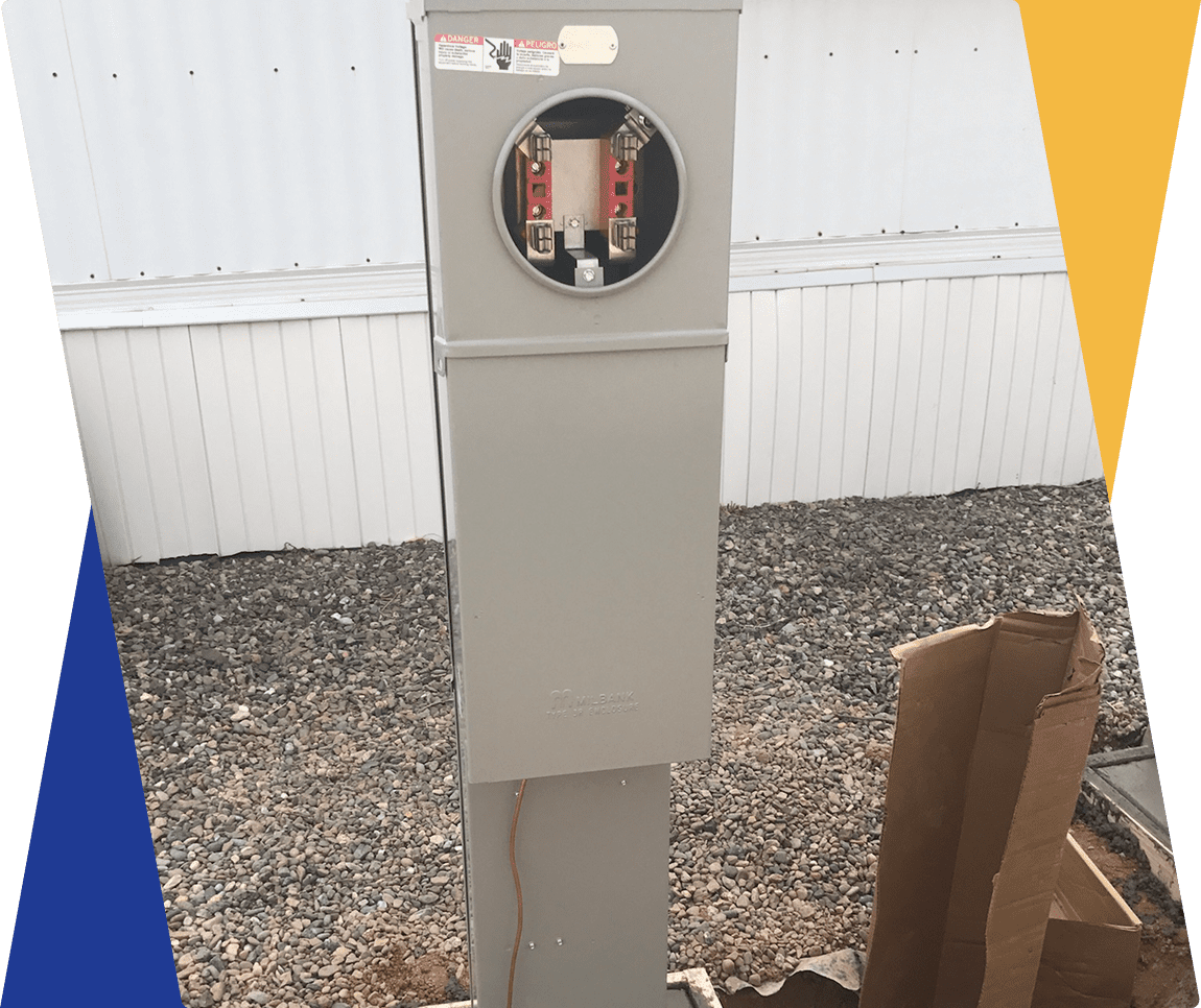 Electrical meter box on gravel ground.